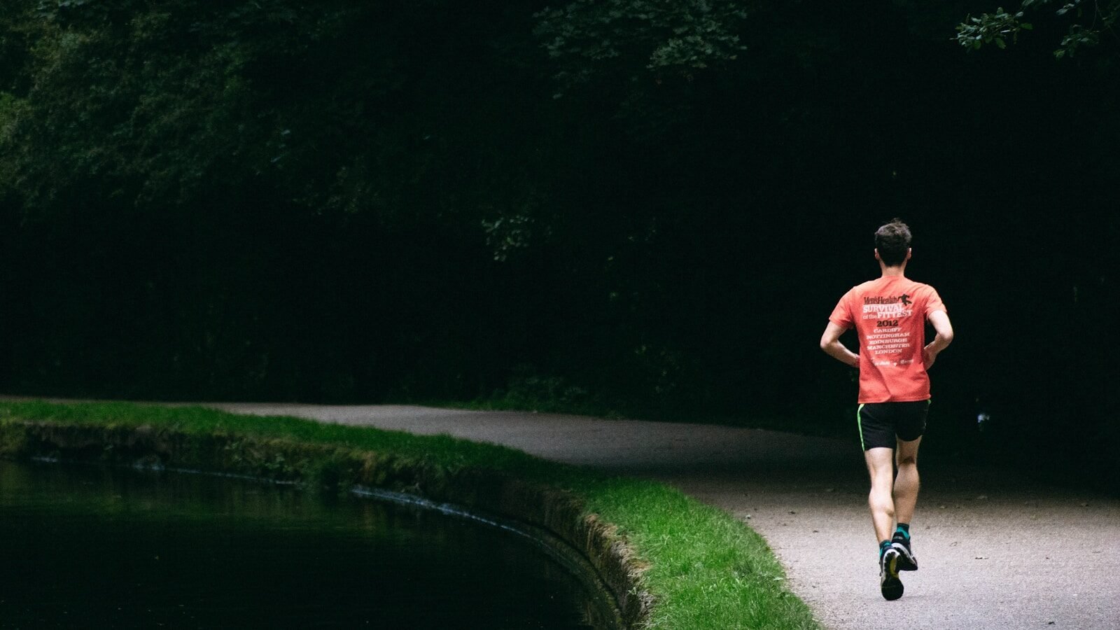person in red shirt standing near river during daytime