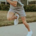 a man in grey shirt and shorts playing a game of tennis
