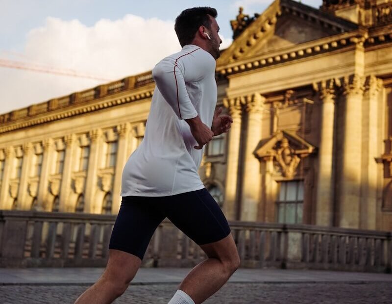 man running near concrete building during daytime